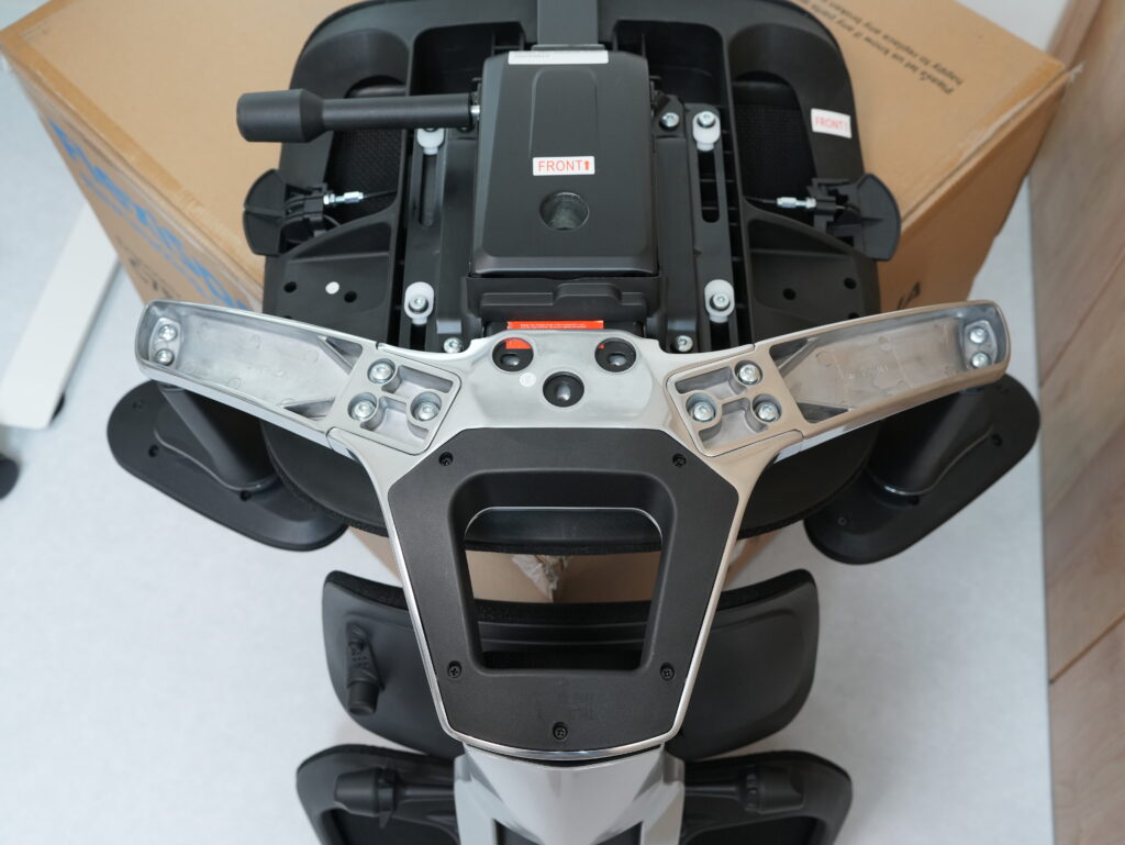 FlexiSpot C7 Morpherを、梱包用の段ボールの上に置いて組み立てている写真1